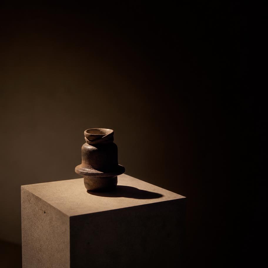 Unnamed ceramic sculpture lit on a concrete plinth